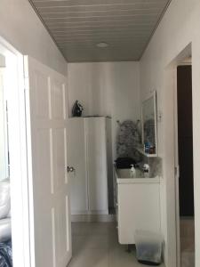 a white kitchen with a refrigerator and a door at JEANOEL Chateau Cozy 2beds 1bath apartment in San Fernando