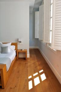 a bedroom with a bed and a table and windows at Hotel Boutique Palacio Corredera in Jerez de la Frontera