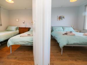 a bedroom with two beds and a mirror at 61 Sea Valley in Bideford