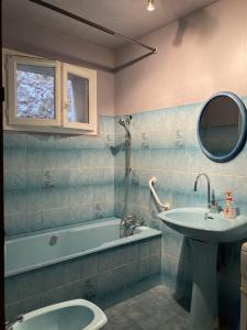 uma casa de banho com um lavatório e uma banheira e um lavatório em La corderie em Sigean