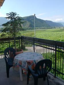 a table and chairs on a balcony with a tree at Pension Flora in Auer