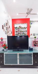 a flat screen tv sitting on top of a entertainment center at The Floral Home in Melaka