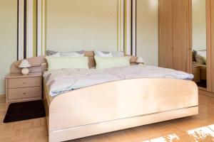 a bed with a wooden frame in a room at Gästehaus Bechtloff in Meißen