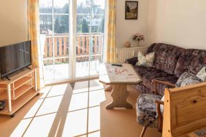 a living room with a couch and a table and a tv at Gästehaus Bechtloff in Meißen