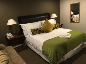 1 dormitorio con 1 cama grande con manta verde en Melville Turret Guesthouse, en Johannesburgo
