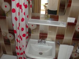 een badkamer met een wastafel en een spiegel bij Pension Flora in Ora/Auer