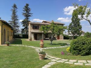 a house with a stone pathway in front of a yard at Agriturismo Residenza il Girasole in Bettona
