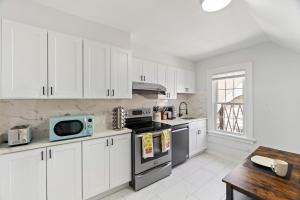 a kitchen with white cabinets and a stove top oven at Cozy Gem in the Heart of East Rock with FREE Parking near Yale and DT in New Haven