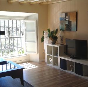 una sala de estar con TV de pantalla plana en un armario blanco en Centro Histórico con parking Cádiz, en Cádiz