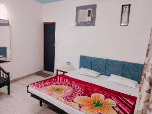 a bedroom with a large bed with a red blanket at Vidya Guest House in Katra