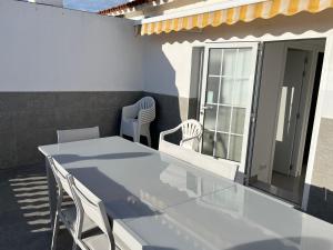 une table et des chaises sur une terrasse avec une fenêtre dans l'établissement Adosado de lujo en Olivanova Golf con 3 dormitorios, à Oliva