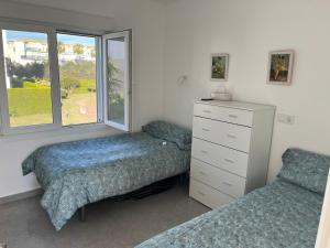 une chambre avec deux lits et une commode et une fenêtre dans l'établissement Adosado de lujo en Olivanova Golf con 3 dormitorios, à Oliva 15 autres photos