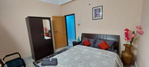 sypialnia z łóżkiem z czerwonymi poduszkami w obiekcie Miltonia Bliss Homestay w mieście Siliguri