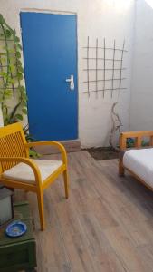 埃拉特的住宿－Carmona's Patio，一间设有蓝色门和黄色椅子的房间