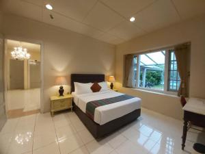 a bedroom with a large bed and a window at Hotel Indah Palace Tawangmangu in Tawangmangu