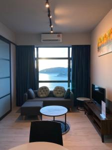 a living room with a couch and a large window at Alawa @ Jesselton Quay Kota Kinabalu in Kota Kinabalu