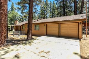 une maison avec deux portes de garage et des arbres dans l'établissement Bohemia Big Bear-1926 by Big Bear Vacations, à Big Bear Lake