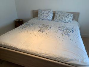 a bed with blue and white sheets and pillows at Gallery Apartment in Blankenberge