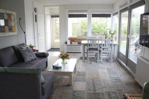 a living room with a couch and a table at Vakantiewoning Dinkelhofje met gratis linnen in Denekamp