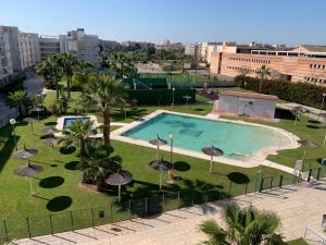 duży basen z parasolami w parku w obiekcie Allo Apartments Europa I Parking Piscina Padel 3 Habitaciones w mieście Jerez de la Frontera