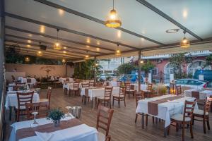 un ristorante con tavoli e sedie bianchi e luci di ALADDIN TSILLIVi a Tsilivi