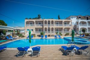 una piscina con sedie e ombrelloni di fronte a un hotel di ALADDIN TSILLIVi a Tsilivi