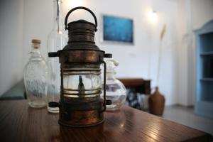 an old lantern sitting on a table with two glass bottles at Apartment Nola in Porozina