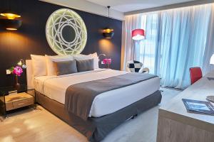 a bedroom with a large bed with a mirror on the wall at Gran Evenia Panamá Hotel in Panama City