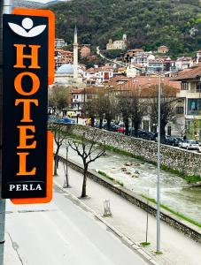 a sign for a hotel on the side of a street at Hotel Perla in Prizren