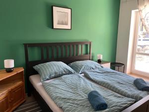 um quarto com uma cama com lençóis e almofadas azuis em Patent, your home in Badacsony em Badacsonytomaj