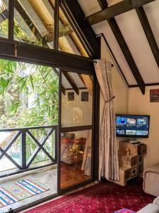 um quarto com uma grande janela numa casa em The Annex at 64 : Cozy, rustic cottage/treehouse em Nairobi