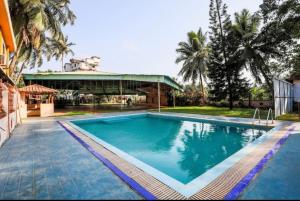 a large swimming pool in front of a building at Hotel Priti International in Mapusa