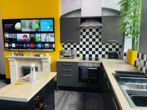 a kitchen with black cabinets and a checkered wall at PHOENIX Boutique Apartments in Goole