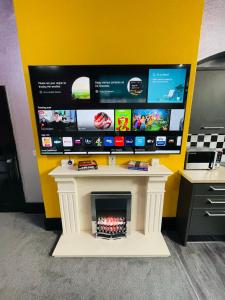 a tv sitting on top of a fireplace in a room at PHOENIX Boutique Apartments in Goole