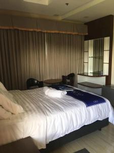 duże łóżko w pokoju hotelowym z krzesłami w obiekcie NutriTECH Hotels & Events w mieście Calapan