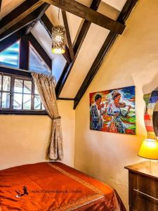 a bedroom with a bed and a painting on the wall at The Annex at 64 : Cozy, rustic cottage/treehouse in Nairobi