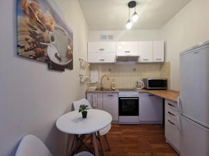eine kleine Küche mit einem kleinen Tisch und einem weißen Kühlschrank in der Unterkunft Euro24 Apartamenty Rumia Klon - studio z balkonem in Rumia