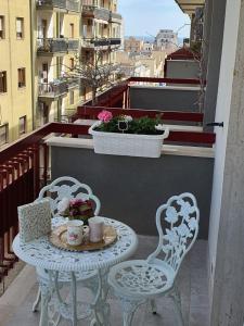 einen Tisch und zwei Stühle auf einem Balkon mit einem Tisch in der Unterkunft Maison Borgomare in Monopoli