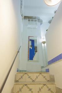 una escalera con paredes azules y blancas y un espejo en ti Porto al Centro Unforgettable Moments, en Salerno