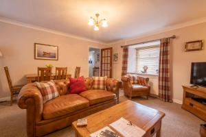 ein Wohnzimmer mit einem Sofa und einem Tisch in der Unterkunft Fisherman's Cottage in Newbiggin-by-the-Sea