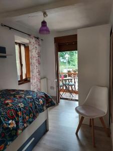 een slaapkamer met een bed en een stoel en een patio bij Casa Rosario in Mieres