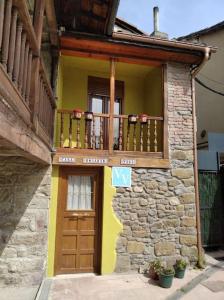 a building with a wooden door and a balcony at Casa Rosario in Mieres
