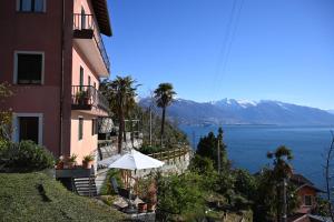 a building with an umbrella next to a body of water at Casa Lago Azzurro Apartement in Cannobio