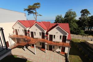 a house with red roofing on top of it at Sunset Przymorze in Rewal