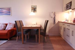 een keuken met een tafel en stoelen en een bank bij Vogelsand 324 in Cuxhaven