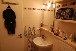 een badkamer met een wastafel, een toilet en een spiegel bij Vogelsand 324 in Cuxhaven