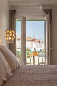 a bedroom with a bed and a window with a view at Mylos Suites in Mýkonos City