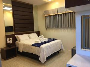 a bedroom with a bed with a black headboard at NutriTECH Hotels & Events in Calapan