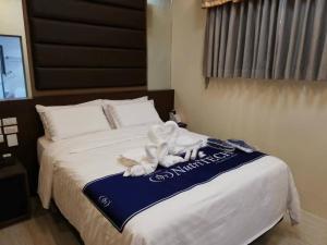 um quarto de hotel com uma cama com uma toalha em NutriTECH Hotels & Events em Calapan