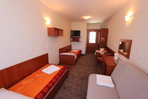 a hotel room with two beds and a couch at Sunset Przymorze in Rewal +18 photos